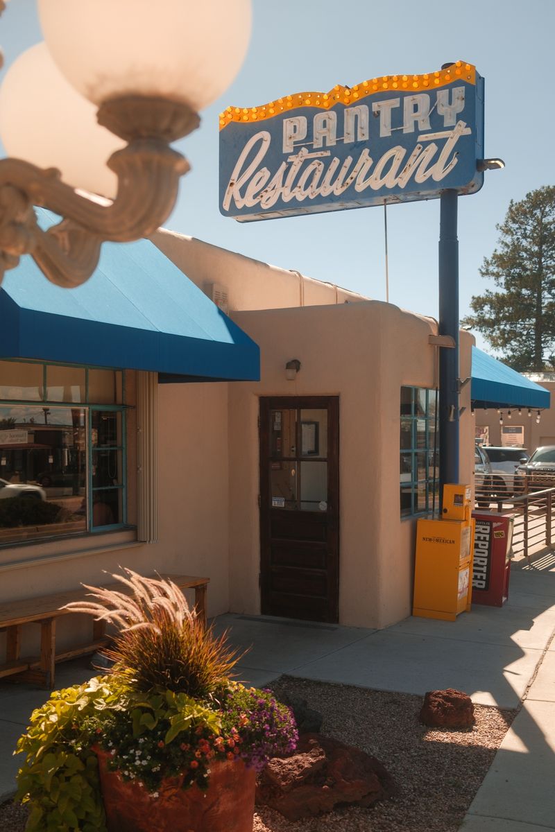 The Pantry on Cerrillos Road: the PANTRY Restaurant sign over the adobe front, the blue awning and the front door.