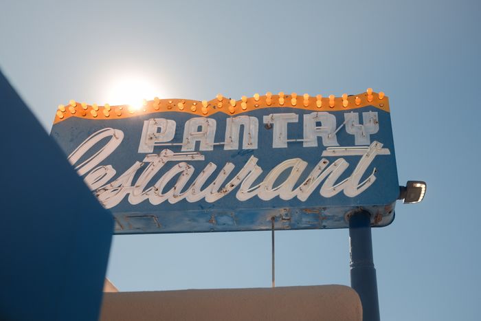 The PANTRY Restaurant sign on Cerrillos Road, its marquee bulbs lit against the sun.