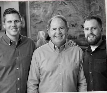 Clint, Stan and Michael Singley smiling in front of the mural.